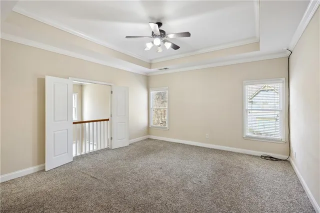 an empty room with windows and ceiling fan