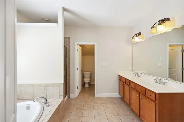 a bathroom with a tub sink and mirror
