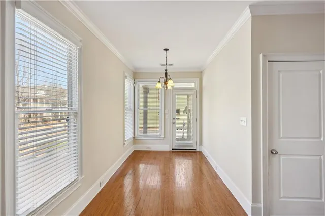 a view of hallway with wooden floor and chandelier