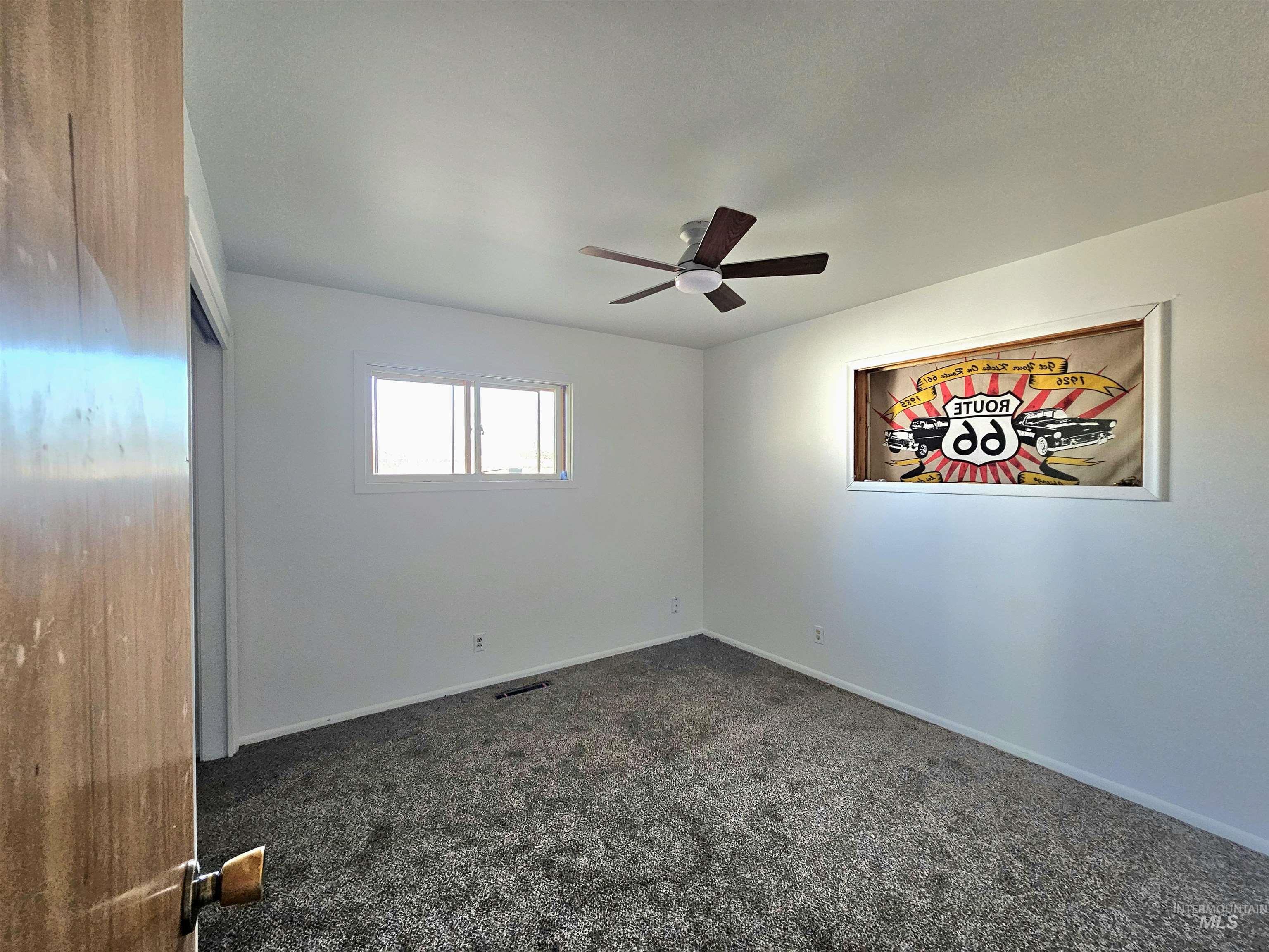 810 South D Street Rupert, ID 83350 - Photo 11 of 23 Empty room with dark carpet and ceiling fan