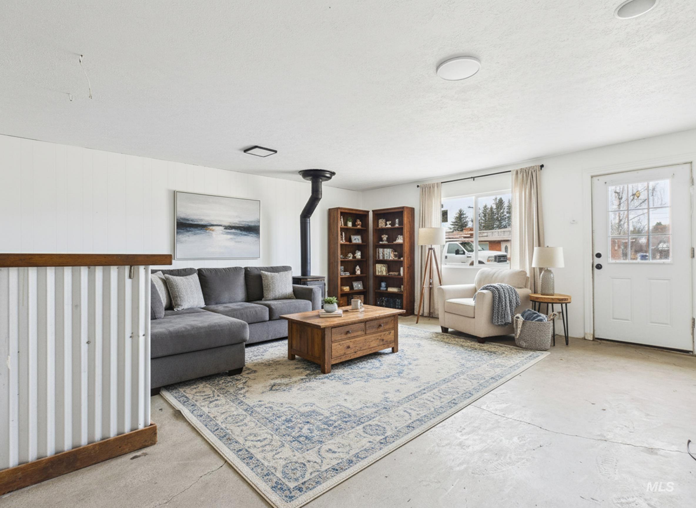 810 South D Street Rupert, ID 83350 - Photo 15 of 23 Living room featuring unfinished concrete floors and a wood stove