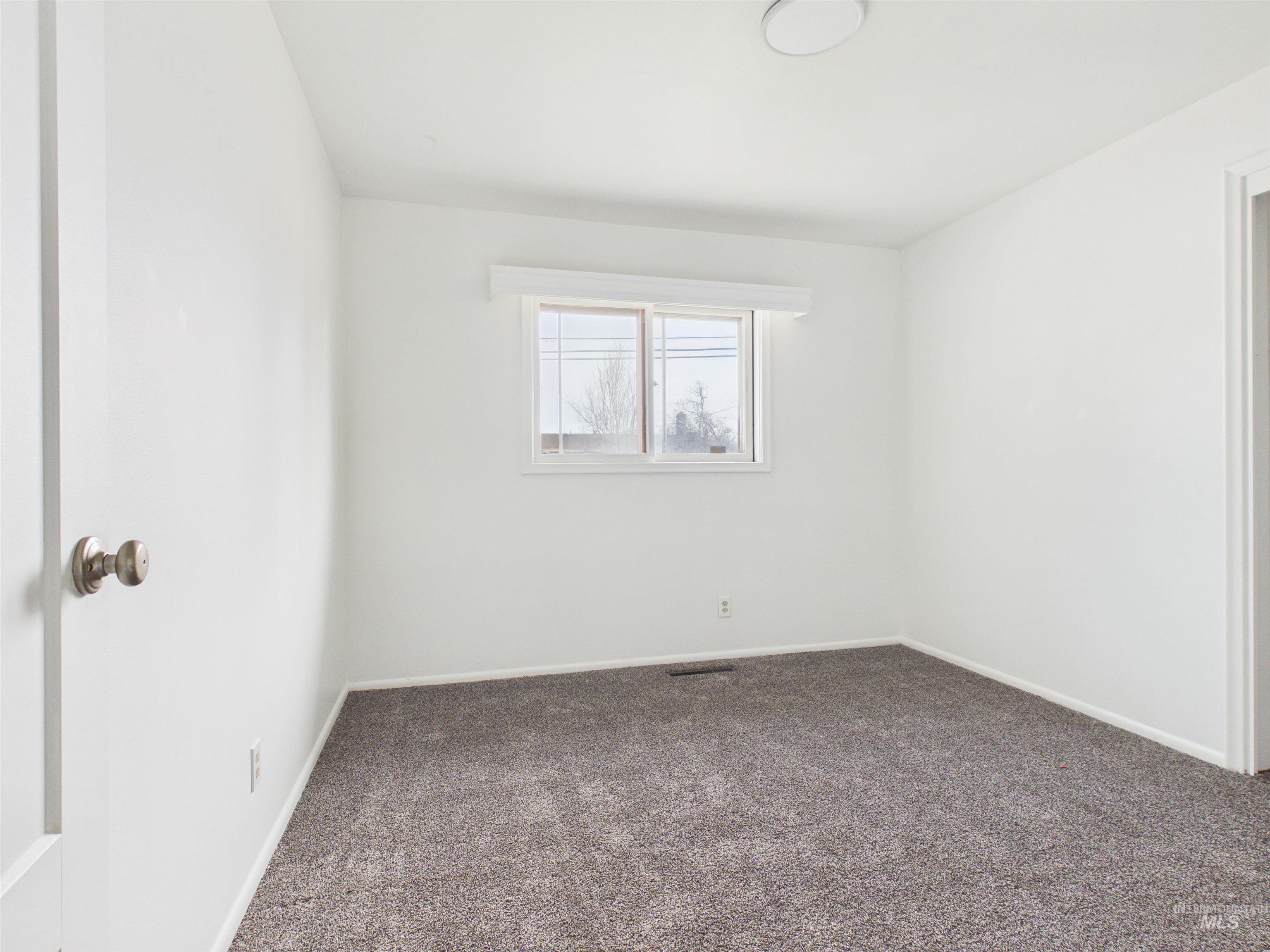 810 South D Street Rupert, ID 83350 - Photo 18 of 23 Empty room with dark carpet and baseboards
