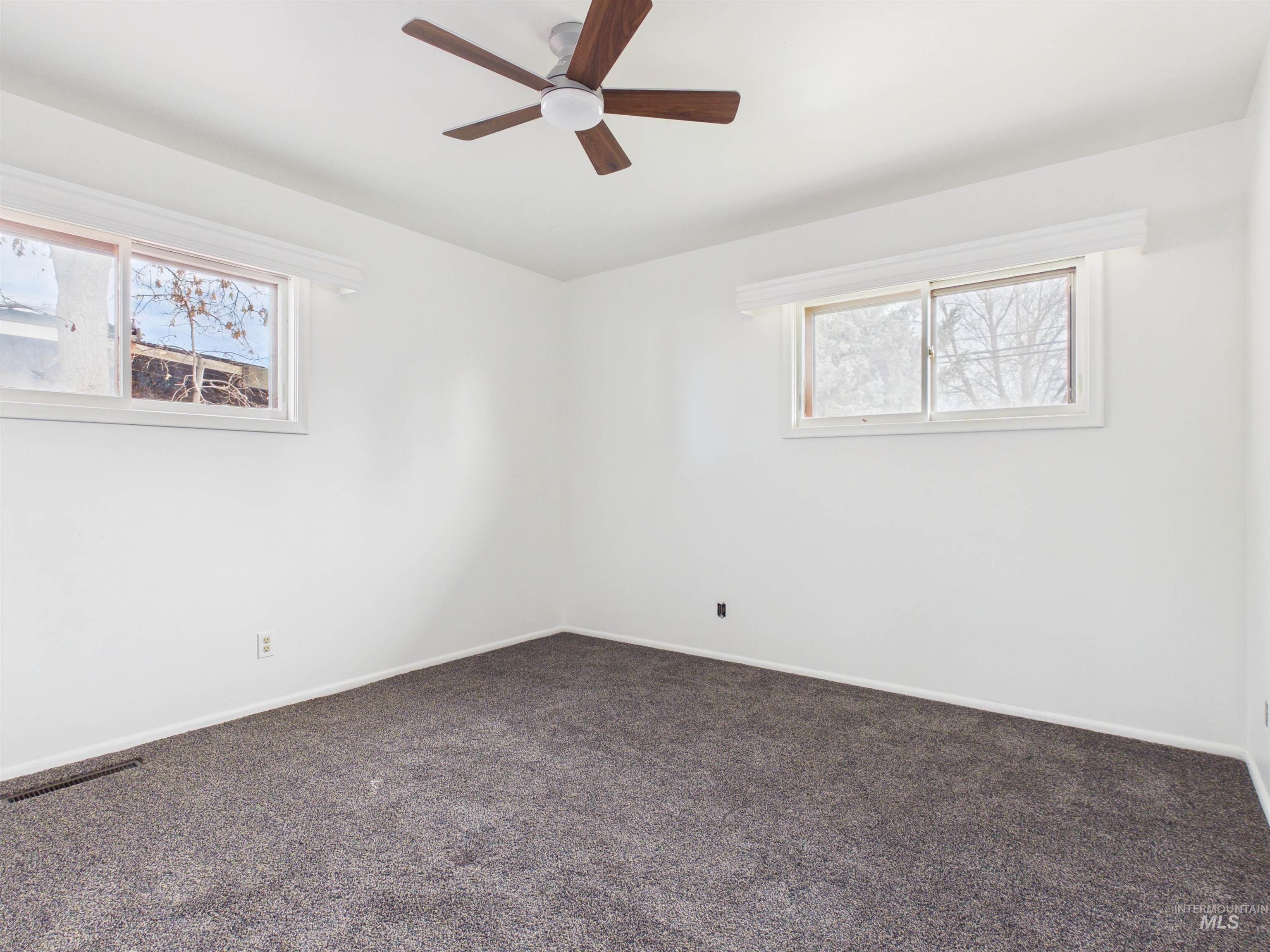 810 South D Street Rupert, ID 83350 - Photo 20 of 23 Spare room featuring dark colored carpet, healthy amount of natural light, and ceiling fan