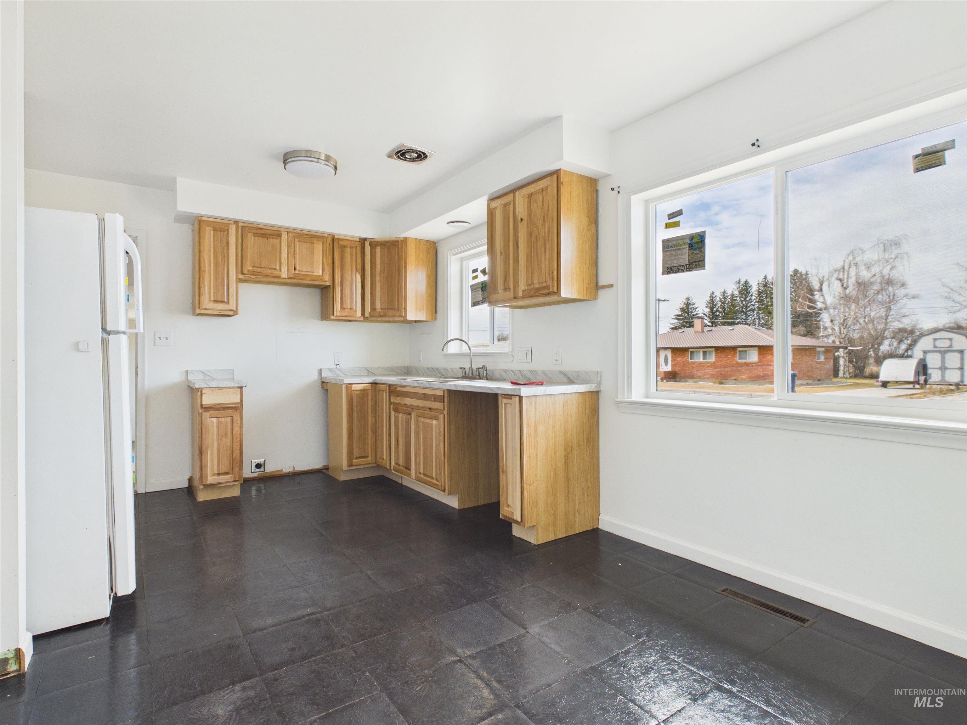 810 South D Street Rupert, ID 83350 - Photo 6 of 23 Kitchen with freestanding refrigerator, light countertops, and stone tile flooring