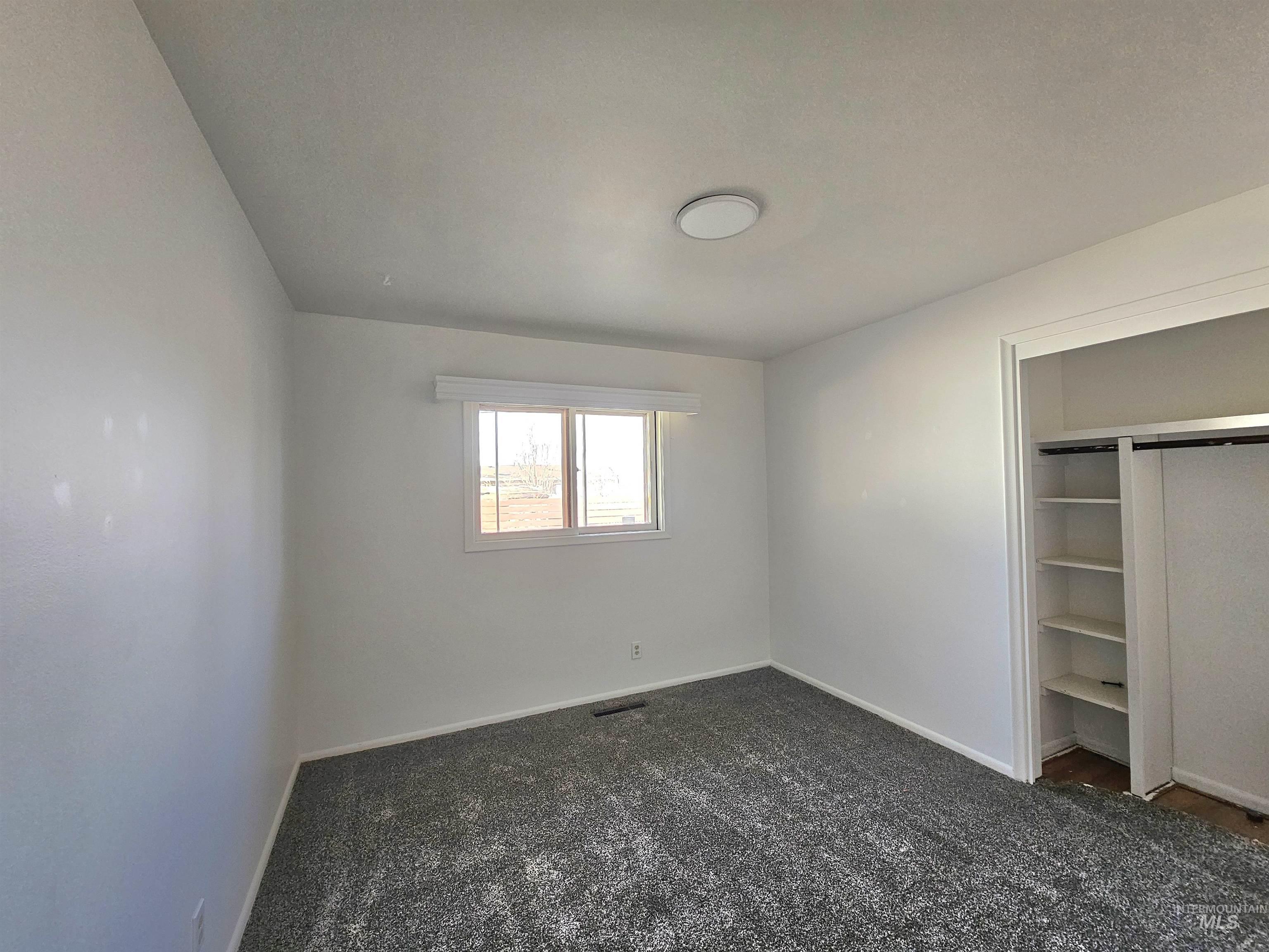 810 South D Street Rupert, ID 83350 - Photo 9 of 23 Unfurnished bedroom with dark colored carpet and a closet
