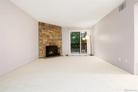 en empty room with windows and fireplace