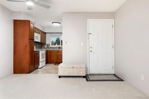 a living room with stainless steel appliances kitchen island granite countertop a refrigerator and a stove top oven