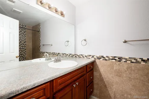 a bathroom with a granite countertop sink and a mirror