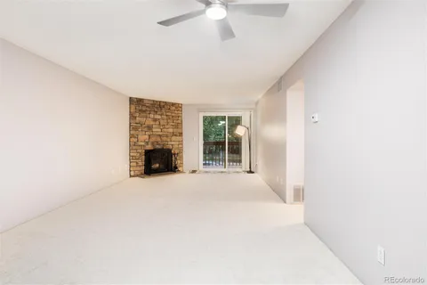 an empty room with fireplace and windows