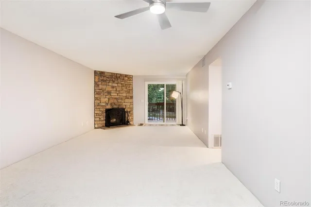 an empty room with fireplace and windows