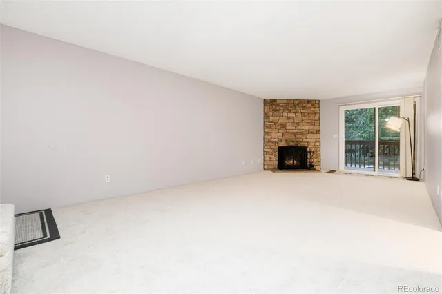 an empty room with fireplace and a window