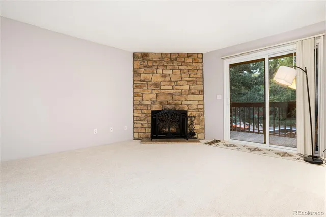 a view of an empty room with a fireplace and a window