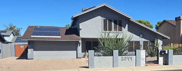 a front view of a house with glass windows and a palm tree