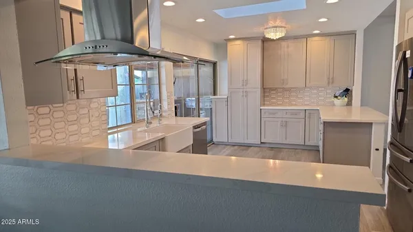 a large kitchen with kitchen island a large counter top space a sink and stainless steel appliances