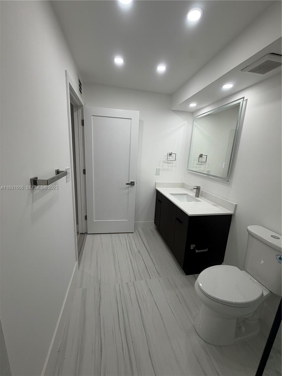 16251 Golf Club Road, Unit 204 Weston, FL 33326 - Photo 12 of 40 a bathroom with a sink a toilet a mirror and vanity