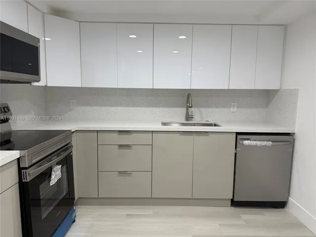 a kitchen with a sink cabinets and stainless steel appliances