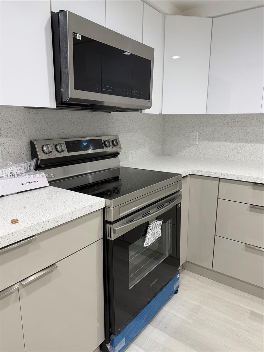 16251 Golf Club Road, Unit 204 Weston, FL 33326 - Photo 5 of 40 a kitchen with a stove and a microwave