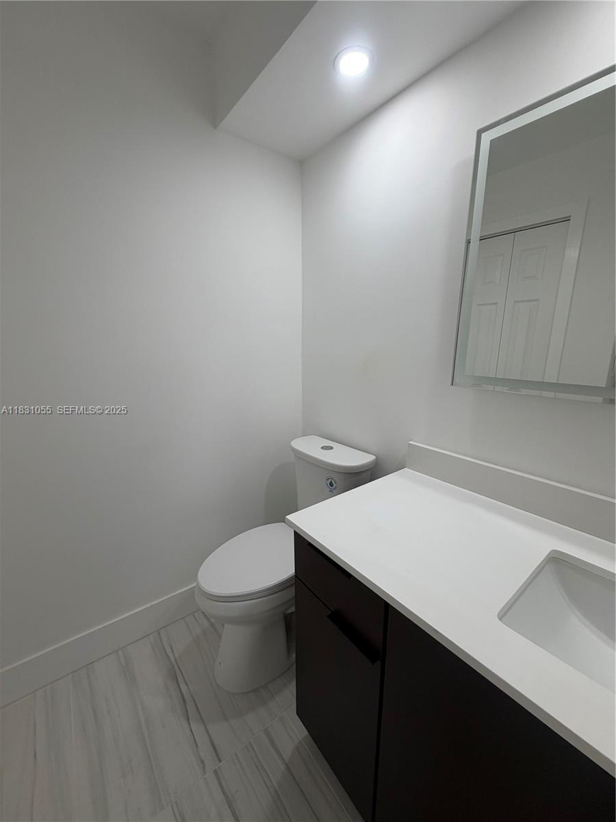 16251 Golf Club Road, Unit 204 Weston, FL 33326 - Photo 8 of 40 a bathroom with a toilet a sink and vanity