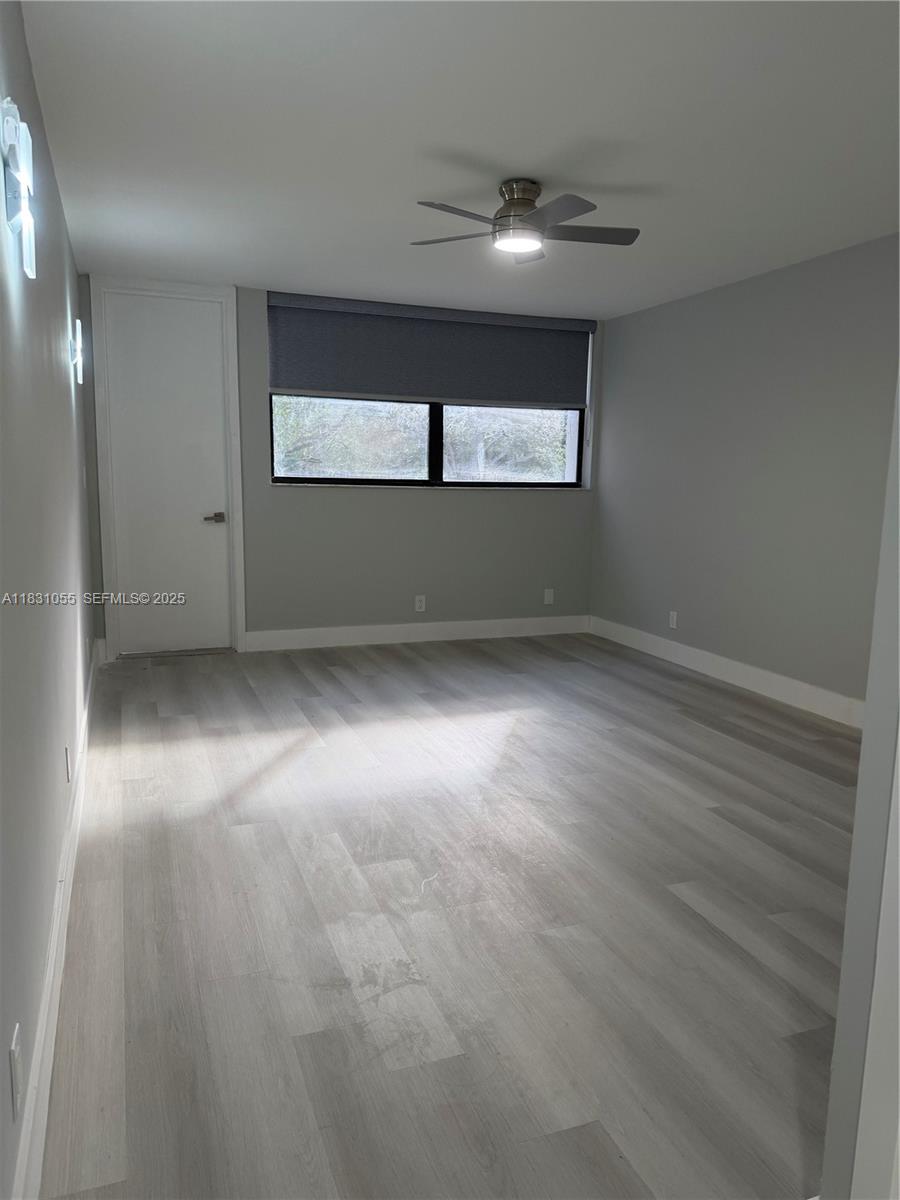 16251 Golf Club Road, Unit 204 Weston, FL 33326 - Photo 9 of 40 a view of empty room with wooden floor and fan