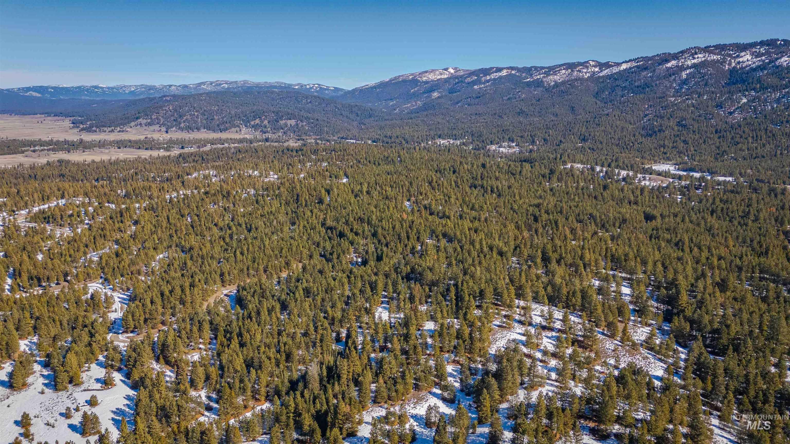 Tbd Skunk Creek Road Cascade, ID 83611 - Photo 14 of 36 Aerial view of property's location with a mountain backdrop and a heavily wooded area