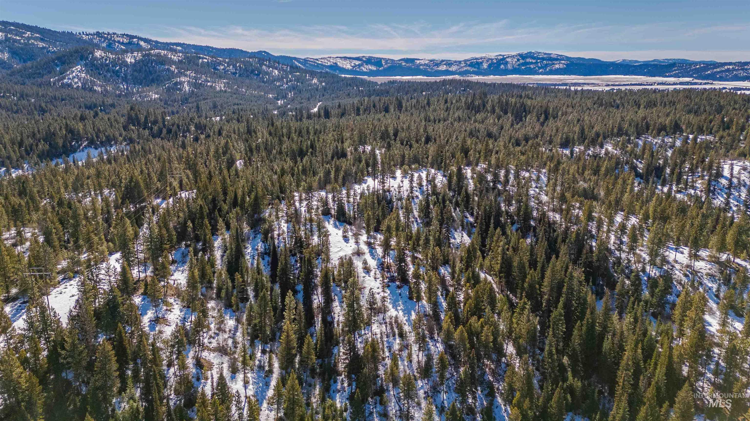 Tbd Skunk Creek Road Cascade, ID 83611 - Photo 19 of 36 Aerial view of property's location with a mountain backdrop and a heavily wooded area