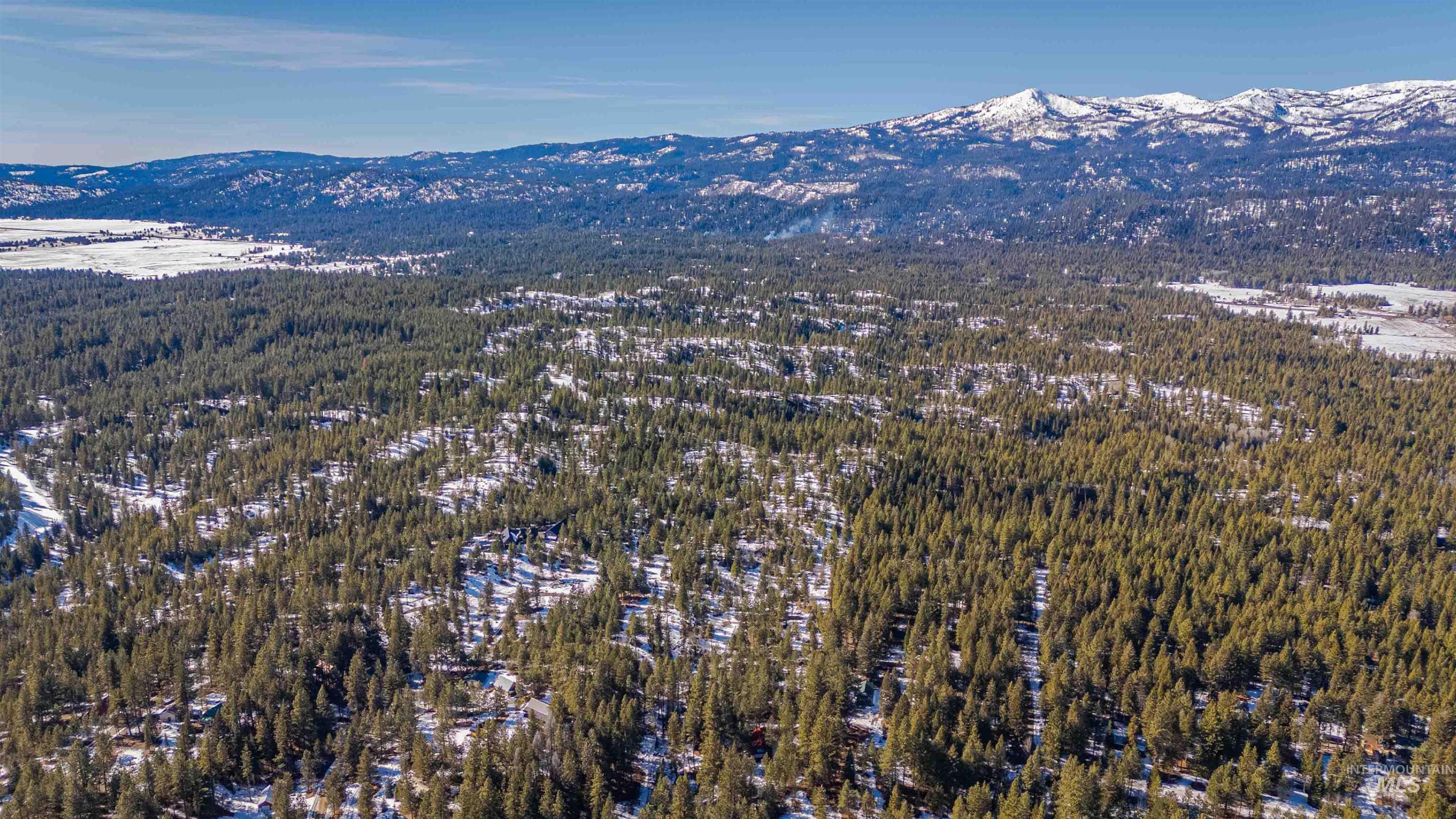 Tbd Skunk Creek Road Cascade, ID 83611 - Photo 23 of 36 Aerial view of property's location with a mountain backdrop and a forest