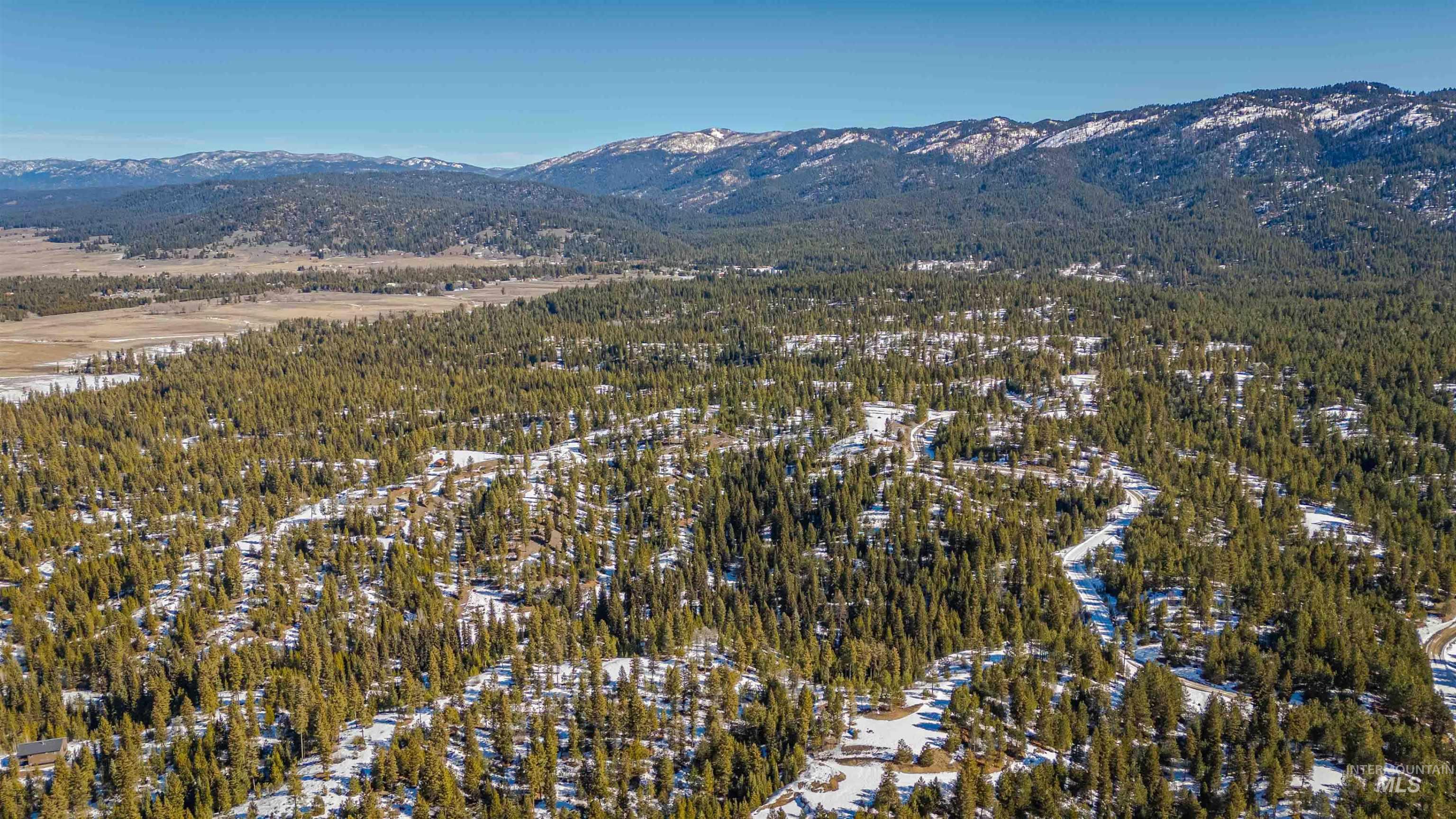 Tbd Skunk Creek Road Cascade, ID 83611 - Photo 9 of 36 Aerial view of a mountain backdrop and a heavily wooded area
