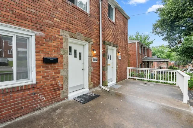 a view of a brick house with a small yard and a large window