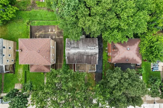 an aerial view of a house with a yard and large tree