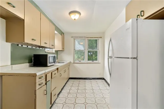 a kitchen with white cabinets and white appliances