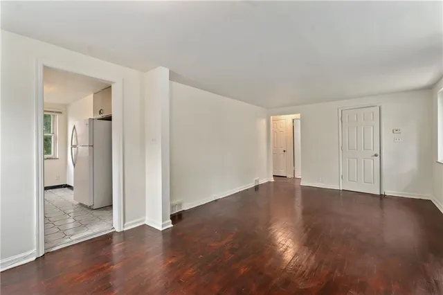 an empty room with wooden floor and a bathroom