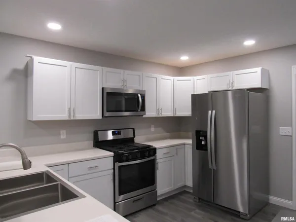 a kitchen with stainless steel appliances a refrigerator a sink a stove a microwave and cabinets