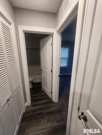 a view of a hallway with wooden floor and staircase
