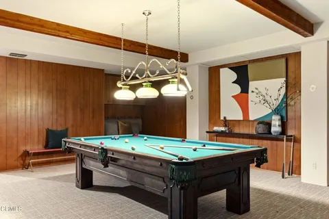 a room with pool table and windows