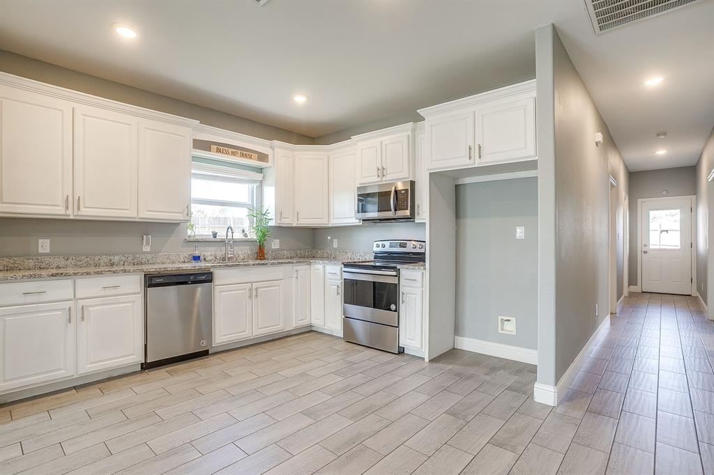 3901 Baylor Street Fort Worth, TX 76119 - Photo 14 of 40 a kitchen with granite countertop white cabinets and white appliances