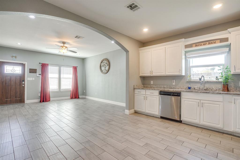 3901 Baylor Street Fort Worth, TX 76119 - Photo 15 of 40 a kitchen with granite countertop a stove a sink and a microwave