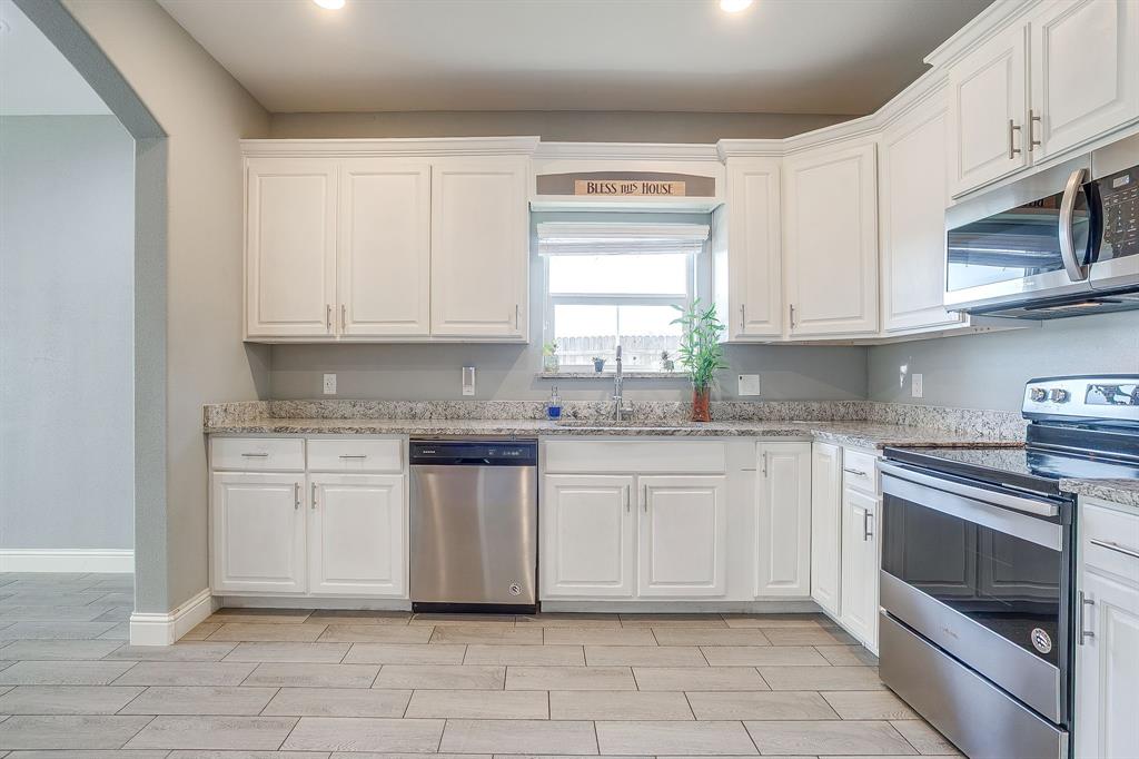 3901 Baylor Street Fort Worth, TX 76119 - Photo 19 of 40 a kitchen with granite countertop white cabinets stainless steel appliances and a sink