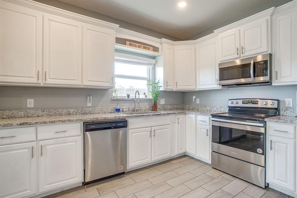 3901 Baylor Street Fort Worth, TX 76119 - Photo 20 of 40 a kitchen with stainless steel appliances granite countertop a stove a sink and a microwave