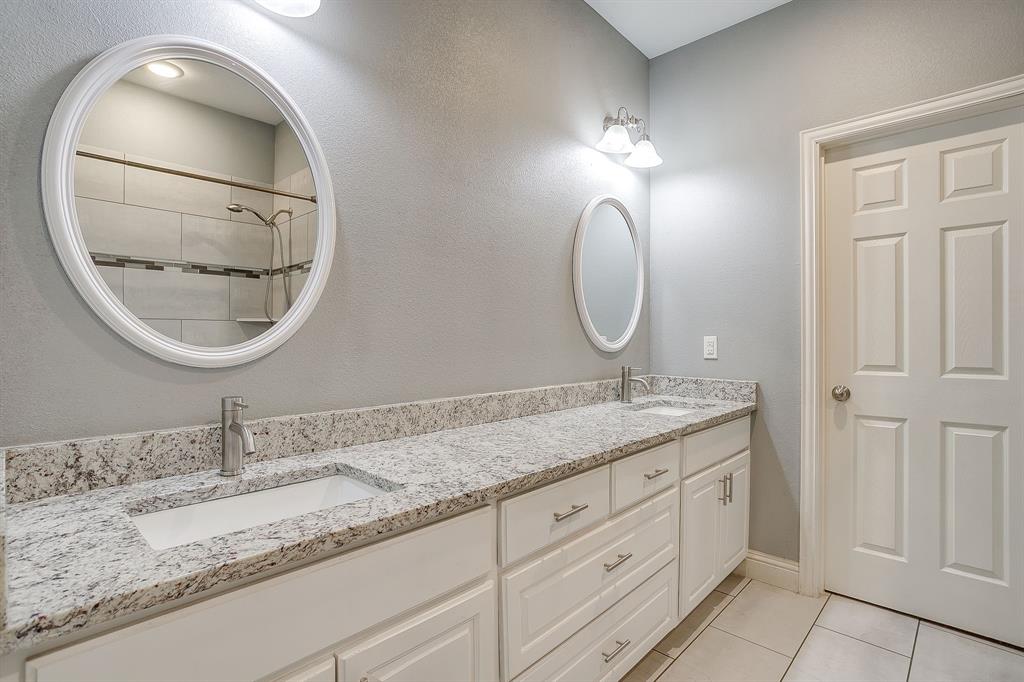 3901 Baylor Street Fort Worth, TX 76119 - Photo 27 of 40 a bathroom with a granite countertop double vanity sinks and a mirror