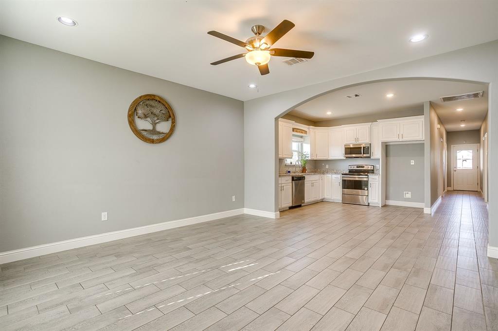 3901 Baylor Street Fort Worth, TX 76119 - Photo 9 of 40 an empty room with wooden floor and a ceiling fan