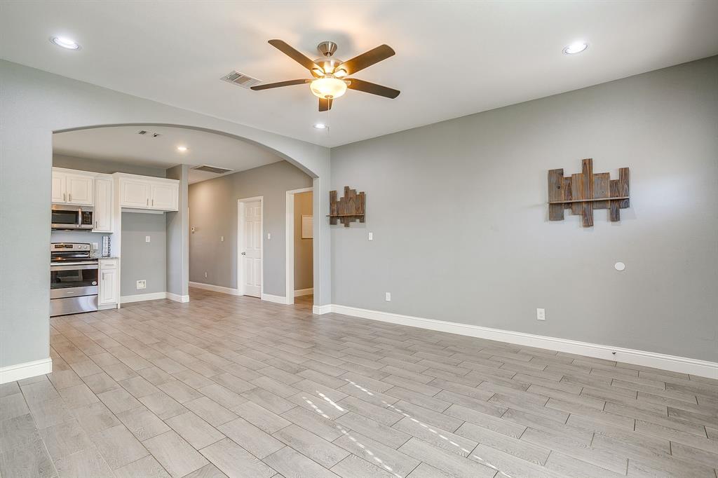 3901 Baylor Street Fort Worth, TX 76119 - Photo 10 of 40 an empty room with kitchen view and a ceiling fan