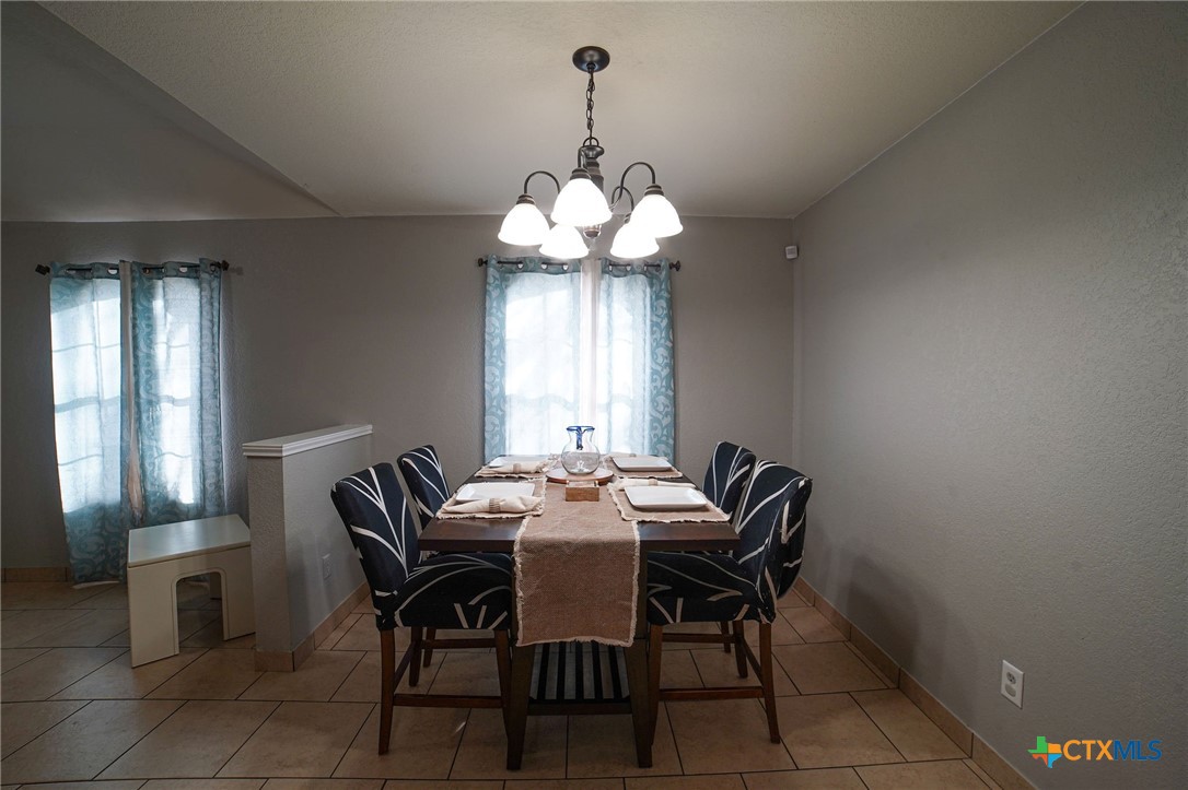 805 James Loop Killeen, TX 76542 - Photo 15 of 31 a dining room with wooden floor a chandelier a wooden table and chairs
