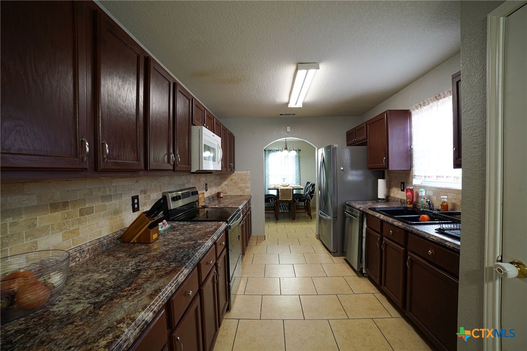 805 James Loop Killeen, TX 76542 - Photo 4 of 31 a kitchen with granite countertop stainless steel appliances and wooden cabinets
