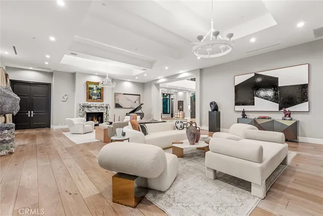 a view of a dining room kitchen with stainless steel appliances kitchen island granite countertop a dining table and a chandelier