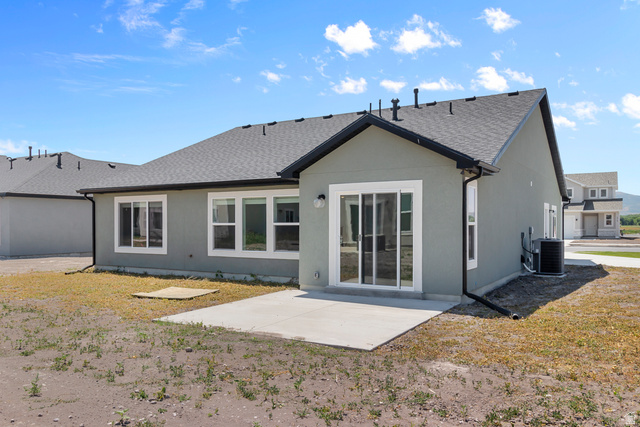 537 South Rivergate Drive Logan, UT 84321 - Photo 3 of 20 Rear exterior featuring a concrete patio, multiple windows with white frames, and a sliding glass door