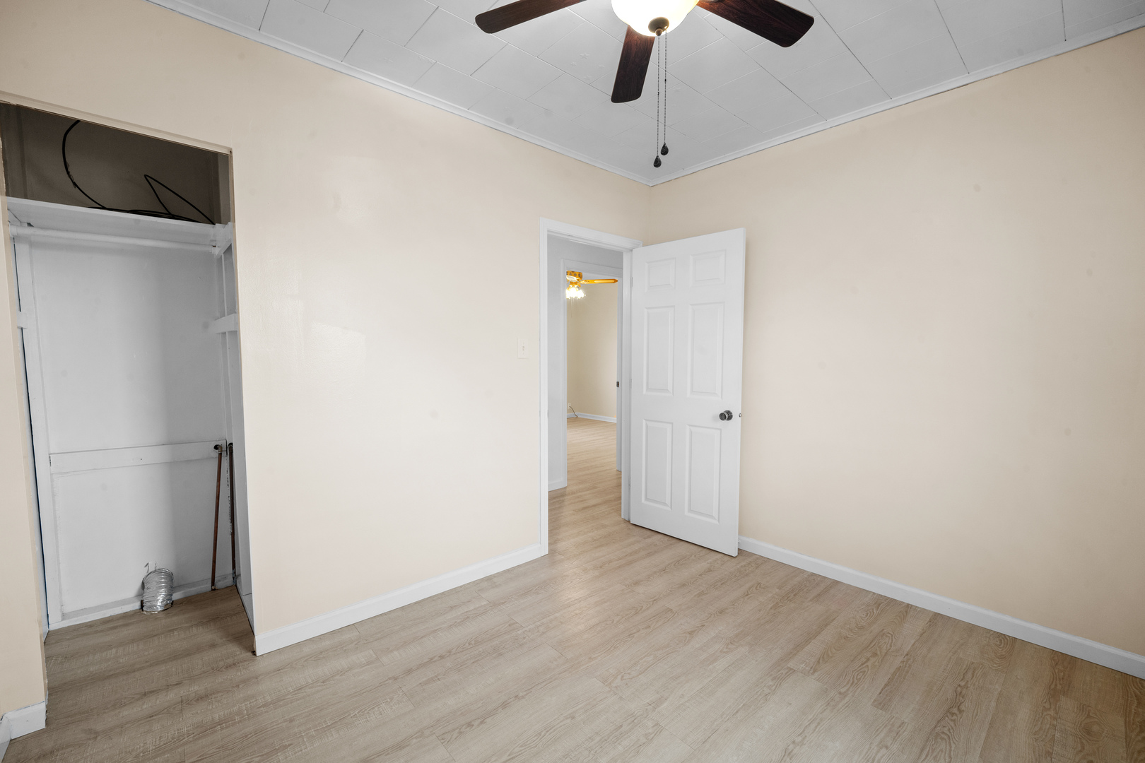 730 5th Street Buffalo, IA 52728 - Photo 11 of 16 an empty room with wooden floor cabinet and a ceiling fan