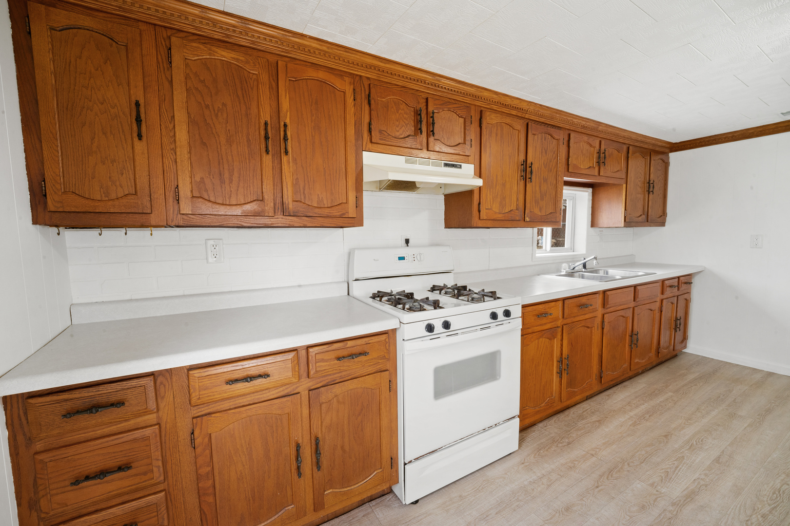 730 5th Street Buffalo, IA 52728 - Photo 4 of 16 a kitchen with granite countertop wooden cabinets and white appliances