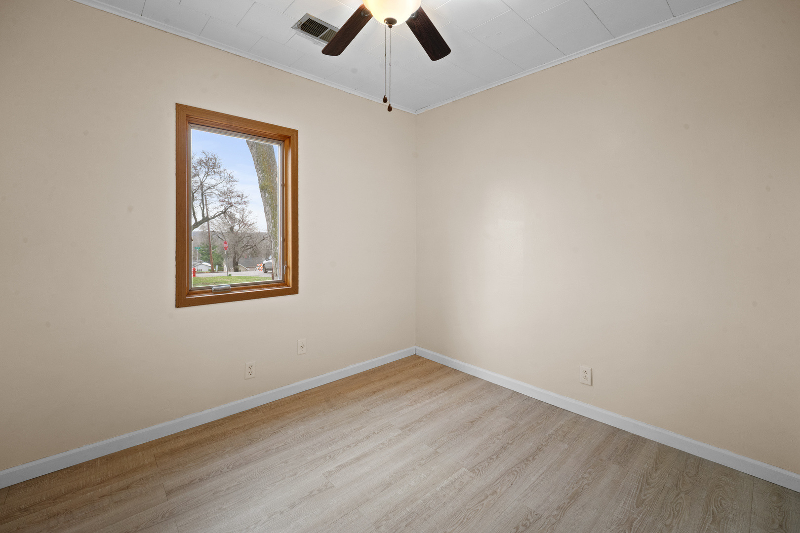 730 5th Street Buffalo, IA 52728 - Photo 10 of 16 an empty room with a window and a ceiling fan