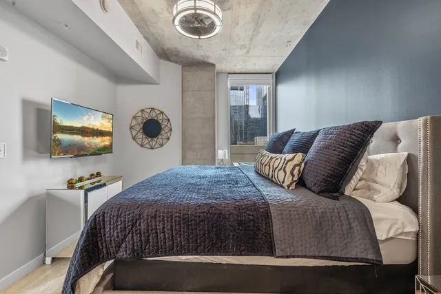 a bedroom with a bed and a flat screen tv