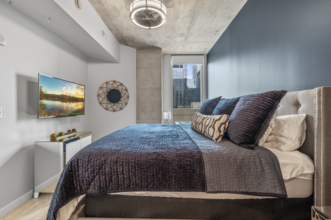 360 Nueces Street, Unit 911 Austin, TX 78701 - Photo 11 of 31 a bedroom with a bed and a flat screen tv